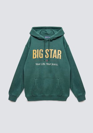 Sudadera verde hecha de tejido suave, con un bolsillo frontal, capucha con cordón y texto en amarillo brillante: "BIG STAR Tu Vida. Tus Jeans."