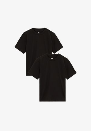 Zwei schlichte schwarze T-Shirts mit kurzen Ärmeln und Rundhalsausschnitt, eines leicht hinter dem anderen, mit kleinen Logotags an den linken Ärmeln.