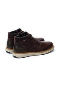 Brown leather ankle boots with a smooth finish, round toe, cushioned inside, and rubber sole featuring a contrasting stitched edge.