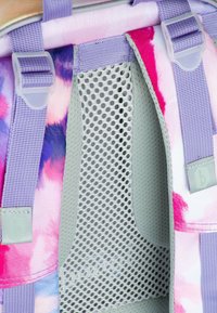 Interno dello zaino a tie-dye viola e rosa con pannelli in rete, spallacci regolabili e dettagli grigi. Presenta una fodera testurizzata e Hardware.