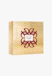 Gullboks med pregete blomsterdesign, med et maroon emblem og hvit etikett som sier "ELIE SAAB ELIXIR LOVE." Rent, elegant design.