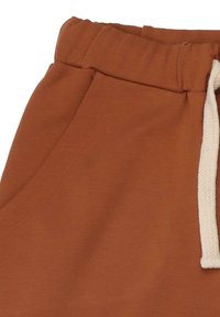 Ein rustikaler brauner Jogginghose mit elastischem Bund und weißem Kordelzug. Verfügt über Seitentaschen und einen weichen, glatten Stoff.