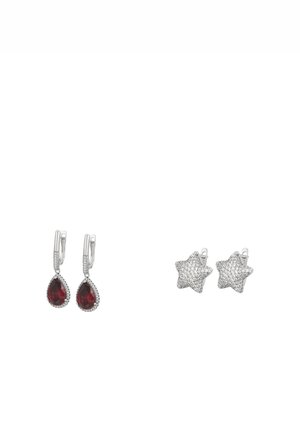To par sølvøreringe: den ene med dråbeformede røde ædelstene, den anden stjerneformet dækket af små klare krystaller.