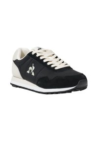Sneaker atletiche in bianco e nero con tomaia in pelle liscia, dettagli in suede e suola in gomma testurizzata; presenta chiusura con lacci e dettaglio del logo.