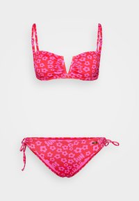 Biquíni vermelho com padrão floral rosa, top com soutien estruturado almofadado e alças ajustáveis, e parte de baixo com nó lateral sobre fundo branco.