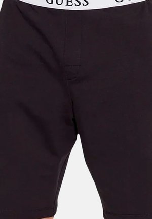 Shorts noirs ajustés avec une ceinture élastique blanche portant le nom de la marque GUESS en lettres majuscules noires.