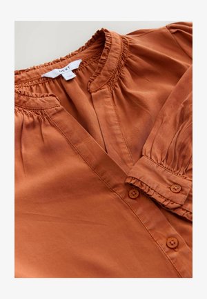 Rust-colored blouse featuring a soft fabric, gathered neckline, button placket, and puffed sleeves with elastic cuffs.