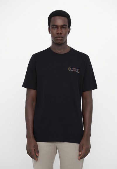 Schwarzes Baumwoll-T-Shirt mit kurzen Ärmeln, das ein mehrfarbiges, rundes Logo auf der Brust gestickt hat. Glatte Textur, klassischer Schnitt.