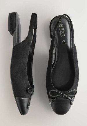 Chaussures slingback noires avec une tige en suède, un bout pointu, un capuchon en cuir et un détail de nœud décoratif. Talon bas et finition intérieure lisse.