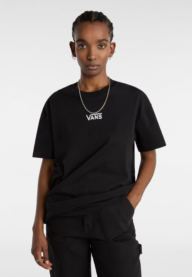 Sort bomulds T-shirt med et hvidt "VANS" logo på brystet, korte ærmer og en afslappet pasform. Matchet med sorte bukser.