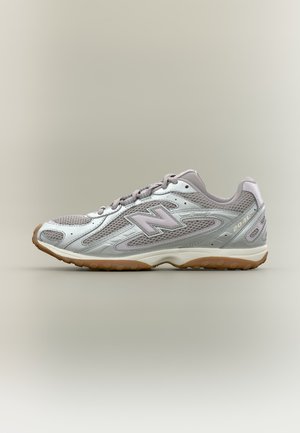 Baskets New Balance gris et blanc avec panneaux en mesh et semelle en gomme, étiquetées "204L", vues de profil sur fond neutre.