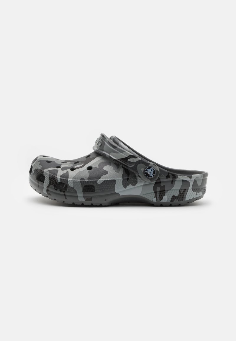 Sabot en camouflage gris en matériau imperméable. Doté de trous de ventilation, d'une sangle arrière et d'une semelle texturée pour une meilleure adhérence.