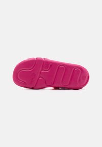 Pink rubber shoe sole with textured pattern and raised curves. Marked with "superfit" and size "28." Smooth finish, flexible design.