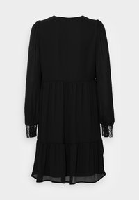 Black dress with long sleeves, tiered design, and shiny buttoned cuffs. Made of lightweight fabric with a smooth texture.