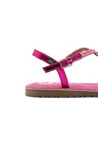 Sandalias fucsias con tiras metálicas brillantes, plantillas texturizadas y suela de goma marrón claro. Detalle de hebilla ajustable.