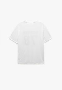 Hvid t-shirt med kort ærme og blødt stof, med "NUMMER 78" trykt på ryggen i en falmet stil. Enkel rund halsudskæring.