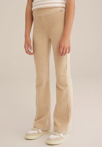Beige ribbed flared pants with a stretchy waistband, featuring a textured surface and a small metallic accent on the waist.