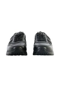 Chaussures de sport noires avec une tige en cuir lisse, un laçage à l'avant et une semelle en caoutchouc texturée. Présente des panneaux subtils et des détails de couture.