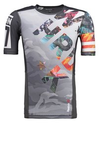 Krátkosrsté sportovní tričko v šedé barvě se živými grafickými vzory, včetně maskáče a barev, s logem a akcenty Reebok.