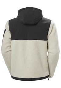 Chaqueta de forro polar con una sección superior de tejido negro y una sección inferior texturizada de color crema. Incluye capucha y dobladillo ajustable.