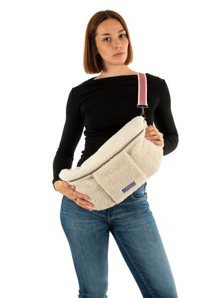 Witte fleece schoudertas met ritssluiting en voorvak. Voorzien van een gestreepte multicolor schouderband. Zacht, gestructureerd oppervlak.