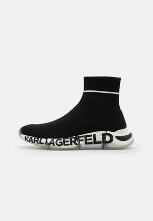 Zapatilla estilo calcetín negra con suela blanca segmentada que presenta el texto "KARL LAGERFELD" en letras negras en negrita.