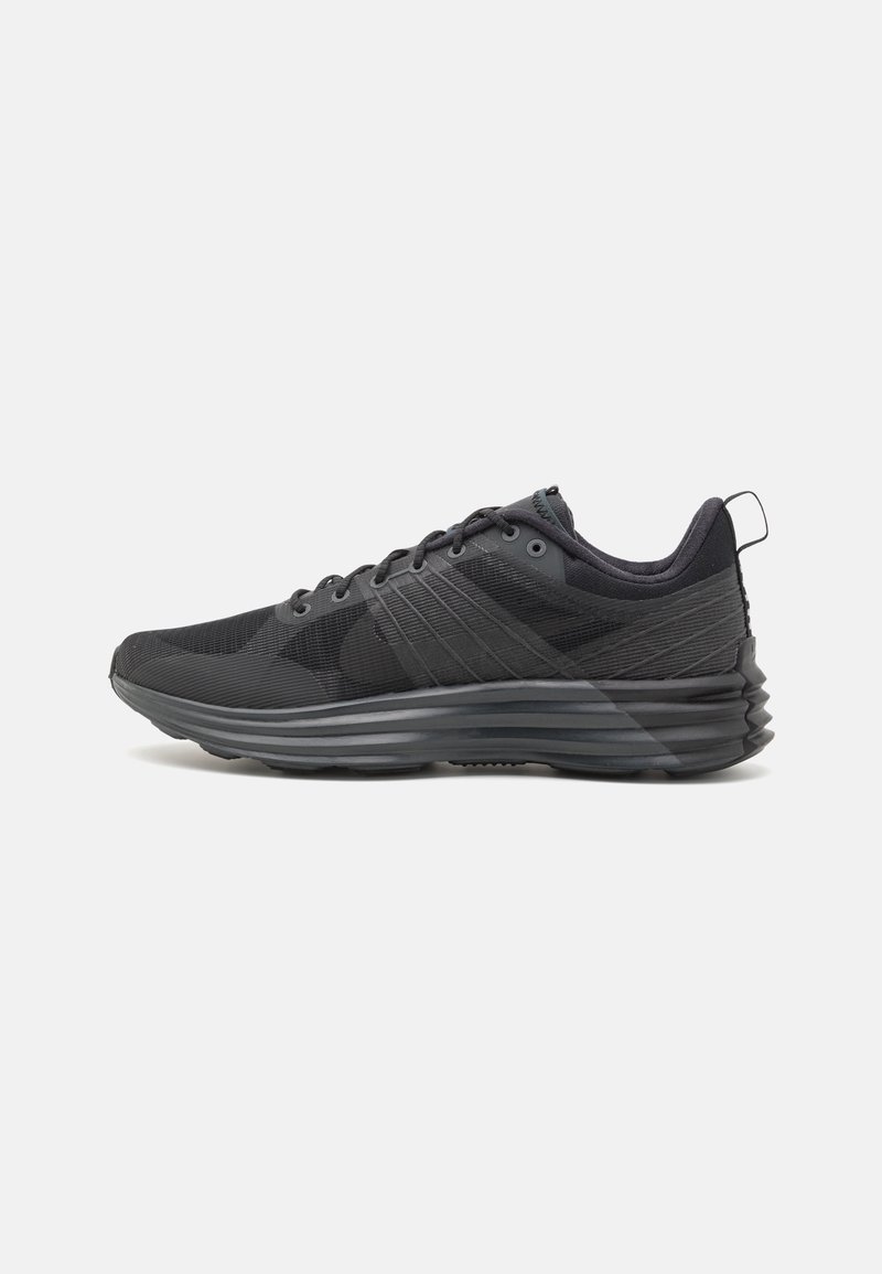 Basket de sport noire avec semelle rembourrée, dessus en mesh, design à lacets et languette à l’arrière, montrée en profil de côté sur fond blanc.