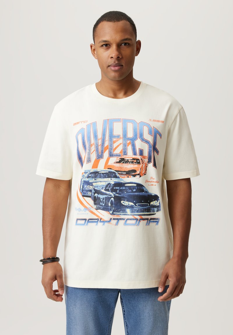 Biała koszulka bawełniana z niebieską i pomarańczową grafiką samochodu oraz napisem "DIVERSE" oraz motywem Daytona, z krótkimi rękawami, luźny krój.