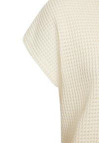 Cremefarbener, strukturierter Stoff mit Waffelmuster, ausgestattet mit kurzen Ärmeln und einer lockeren, entspannten Passform. Das Design ist nahtlos und minimalistisch.