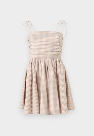 Gingham check dress in beige and white, with a smocked bodice, adjustable tie straps, and a flared skirt.