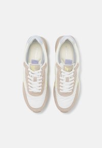 Buty sportowe z białą cholewką ze skóry, beżowymi zamszowymi akcentami, jasnoniebieskim kołnierzem i żółtym logo, wyposażone w białe płaskie sznurówki i wkładkę z logo.