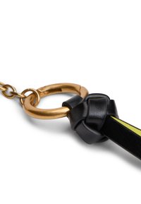 Μαύρο λουράκι από δέρμα με χρυσό μεταλλικό δαχτυλίδι, με σχέδιο κόμπου και κίτρινη αντίθεση κατά μήκος της άκρης. Ορατή αλυσίδα προσάρτησης.