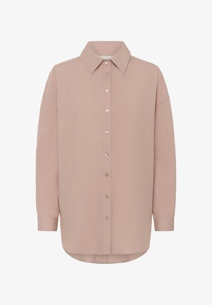 Long-sleeve button-up shirt in muted pink with pointed collar and rounded hem, designed for a loose, relaxed fit.