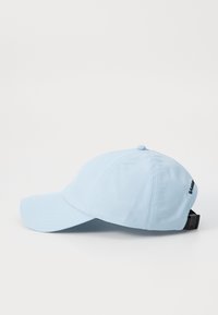 Light blue baseball cap made of soft fabric. Features a curved brim, stitched detailing, and an adjustable black strap at the back.