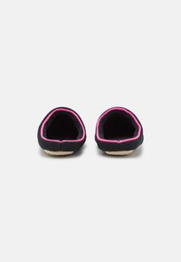 Black slip-on shoes with pink trim, featuring a textured fabric exterior and a soft, cushioned interior. Round toe design.