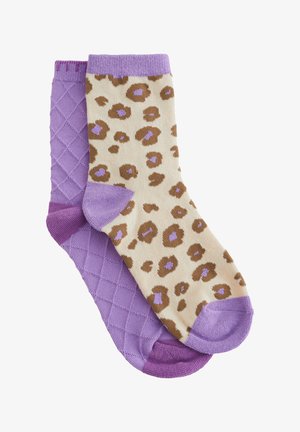Par čarapa do gležnja, jedna ujednačeno ljubičasta s uzorkom rombova, druga bež s smeđim i ljubičastim leopardovim mjestima i ljubičastim detaljima.