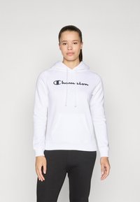 Sweat-shirt à capuche blanche avec poche avant, arbore le logo noir "Champion". Tissu doux, manches longues, poignets côtelés. Coupe décontractée.