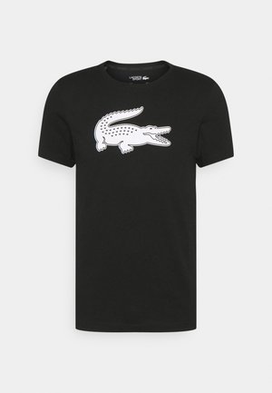 Czarny t-shirt z krótkim rękawem z dużą białą grafiką krokodyla na środku klatki piersiowej, okrągłym dekoltem i oznaczeniem Lacoste Sport wewnątrz kołnierza.