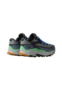 Gray athletic shoes with black mesh and green accents; features blue laces, a textured upper, and a thick, rugged outsole with orange details.