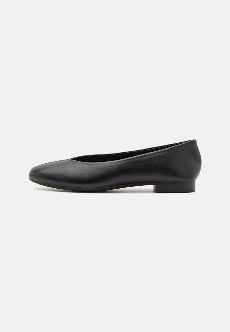 Ballerines en cuir noir avec un bout rond et un petit talon, présentant une texture lisse et un design minimaliste.