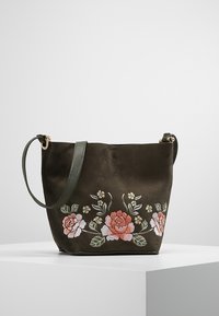 Sac fourre-tout en tissu vert olive avec broderie florale en rose, blanc et vert. Dispose d'une longue bandoulière ajustable et de quincaillerie en or rose.