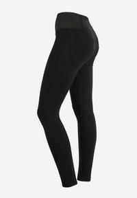 Leggings neri con una vita alta e elastica. Tessuto liscio e elasticizzato con un design aderente. Presentano cuciture contornate nella parte posteriore.