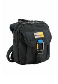 Bolso de hombro de tela negra con un bolsillo frontal, herrajes plateados, un acento azul y un parche de logo amarillo, con cierre de cremallera y correa ajustable.