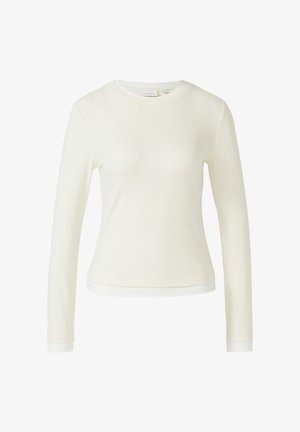 Cream-colored long-sleeve women's crew neck shirt with a slightly fitted shape and a layered hem detail.