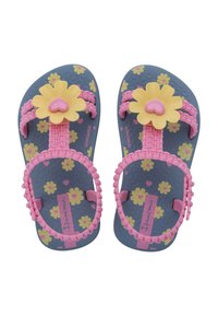 Infradito per bambini con suola blu, cinturini floreali rosa e accenti di fiori gialli. Presentano un dettaglio a forma di cuore sul fiore.