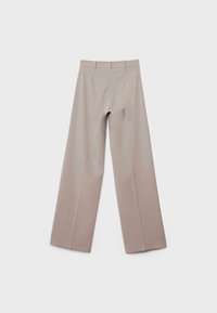 Pantalon beige à jambes larges en tissu texturé, avec une taille haute, des plis au centre et un design épuré et minimaliste.