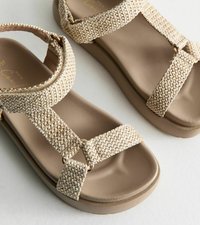 Bruna sandaler med vävda tygremmar, med rund tå och vadderad sula. Designen inkluderar detaljer i guld-ton.