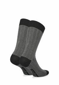 Czarno-szare skarpetki w wzór jodełki, z czarnymi prążkowanymi mankietami i jednolitym kolorem na palcach oraz piętach.
