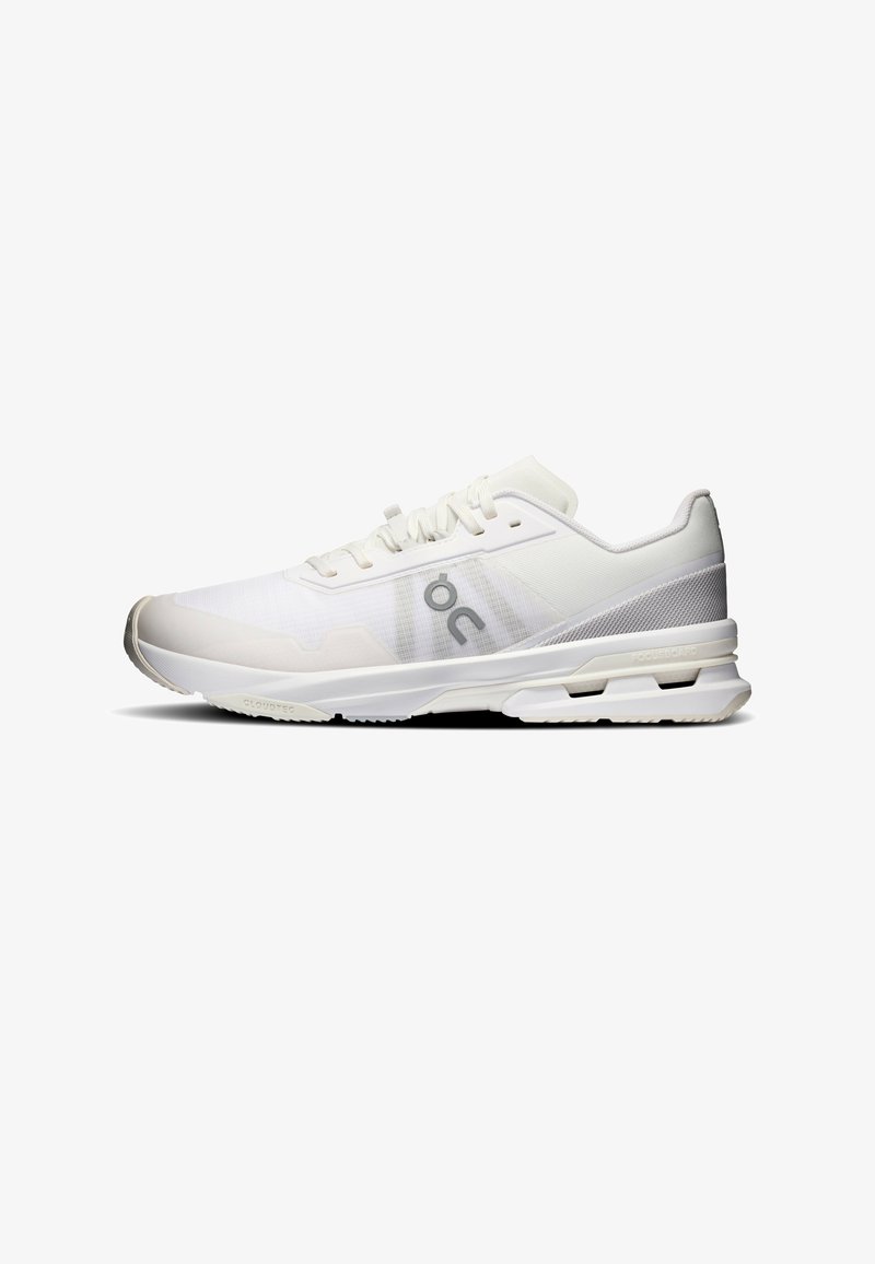 Baskets de sport blanches avec dessus en mesh, fermeture à lacets, semelle épaisse rembourrée et logo gris sur le côté, vue de la gauche.
