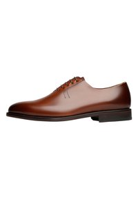 Chaussure habillée en cuir marron avec une finition lisse, bout arrondi, cinq œillets et un faible talon plat. Présente des détails de couture subtils sur la tige.